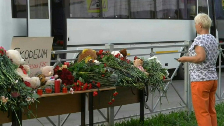 IMAGESSoldiers stand guard and people lay flowers at a makeshift memorial for victims of the shooting at School No. 175 in the central Russian city of Kazan. At least nine people, most of them children, were killed when a lone teenage gunman opened fire.