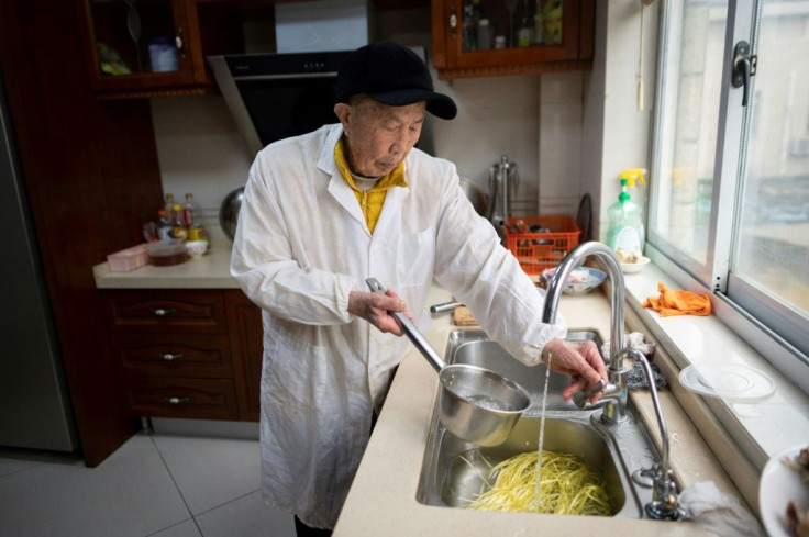 Yu Fuxi, 103, regularly makes meals for his grandchildren, darting around the kitchen in white cooking overalls