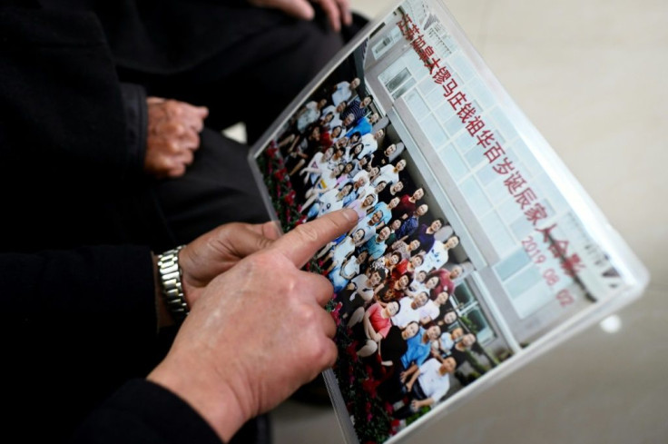 Qian Zuhua shows a family photo in Rugao