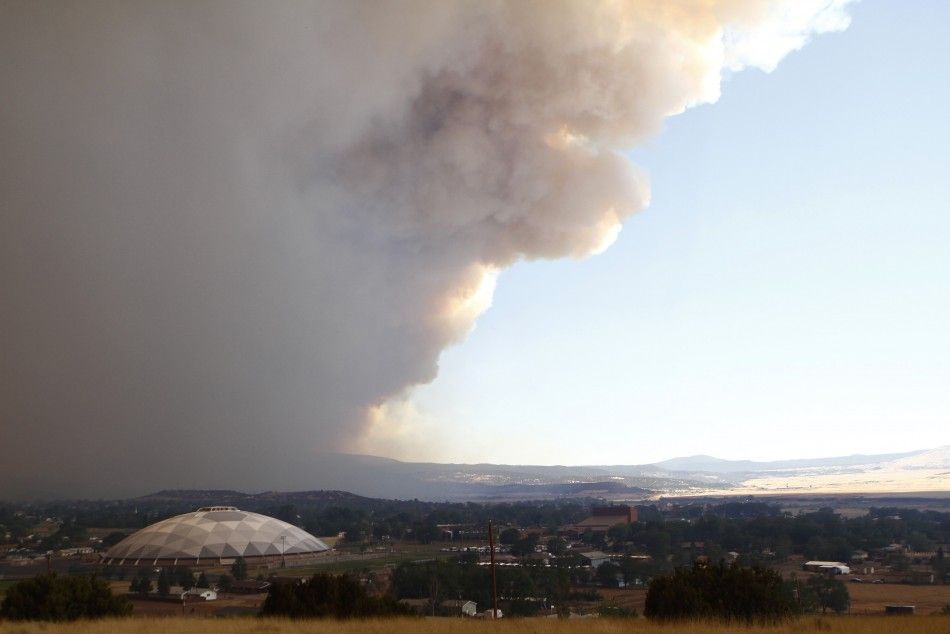 Smoke from the Wallow Wildfire rises over Round Valley High School Stadium in Springerville
