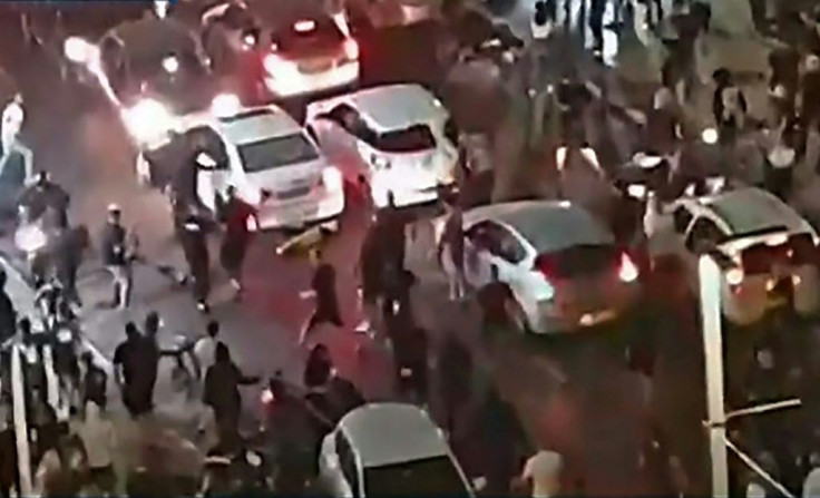 This video grab obtained from footage released by Kan 11 public broadcaster  shows a far-right Israeli mob attacking who they considered an Arab man, on the seafront promenade of Bat Yam, a town south of Tel Aviv