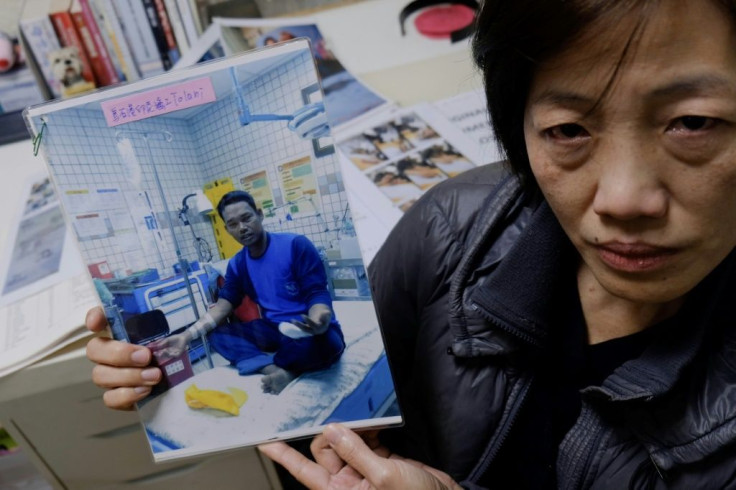 Allison Lee of the Ilan Migrant Fishermen Union holds a picture of missing Indonesian fisherman Tolani