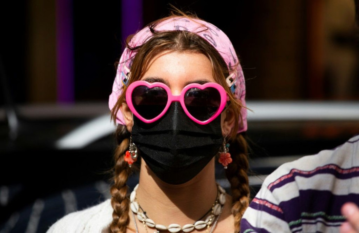A woman wearing a face mask attends the Broadway United for Justice protest as workers commemorate May Day in New York