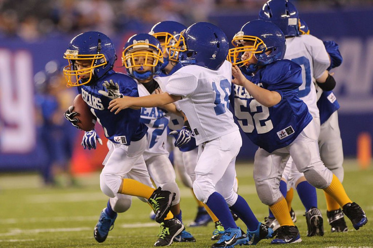 Young boys kids playing American Football 