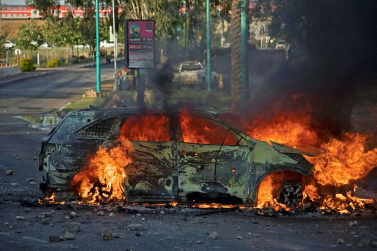 An Israeli police car burns after an Arab Israeli demonstration following the funeral of Mousa Hassouna in the central city of Lod near Tel Aviv on May 11