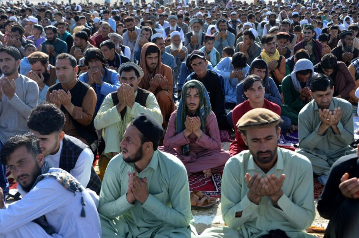 Afghan Muslims pray in the open outside Jalalabad as the government and the Taliban observe a three-day ceasefire for the Eid al-Fitr holiday
