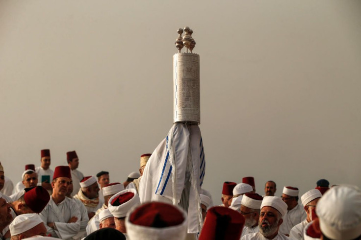 A Samaritan priest raises the Torah scroll as worshippers gather to pray on top of Mount Gerizim, near the northern West Bank city of Nablus during celebrations of Shavuot 