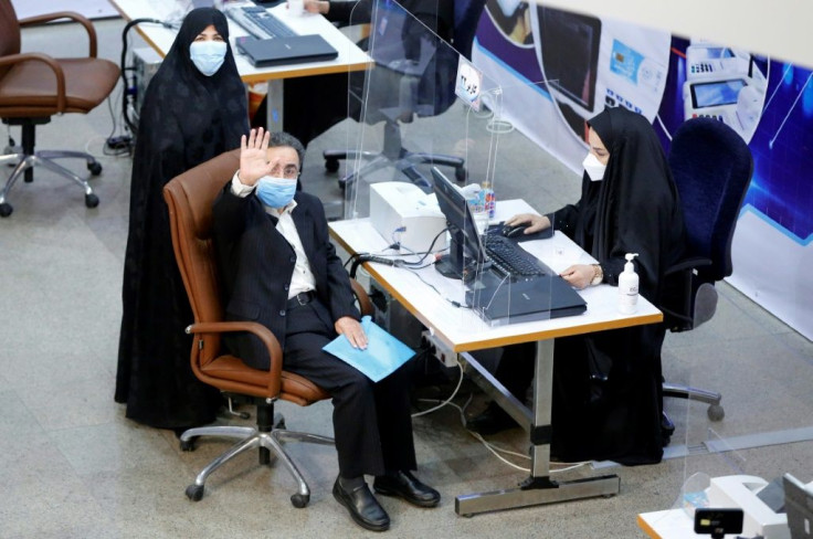 Iranian reformist politician Mostafa Tajzadeh, accompanied by his wife, waves after registering his candidacy on May 14, 2021