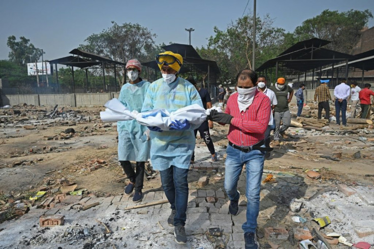 A volunteer carries the body of a child who died of Covid-19, at a crematorium in New Delhi