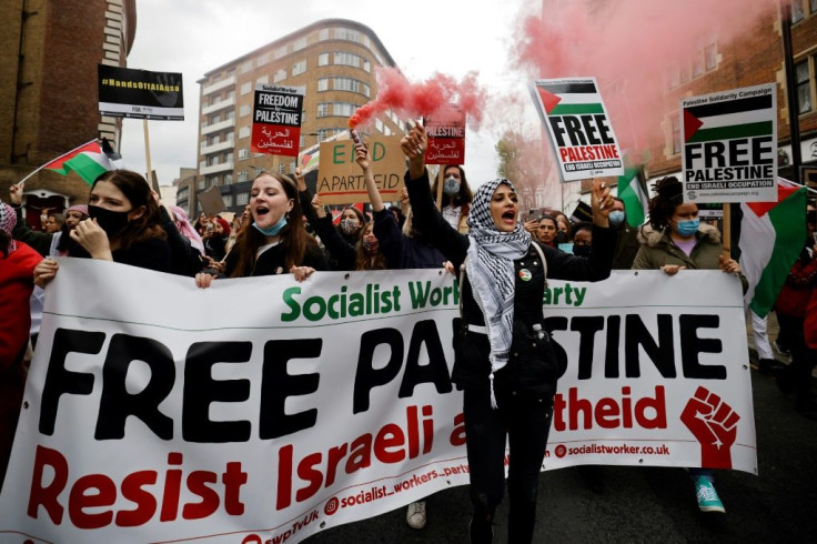 Pro-Palestinian activists and supporters let off smoke flares, wave flags and carry placards in central London