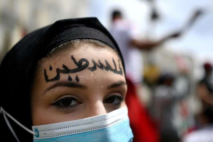A woman sporting the word "Palestine" in Arabic marches in Madrid