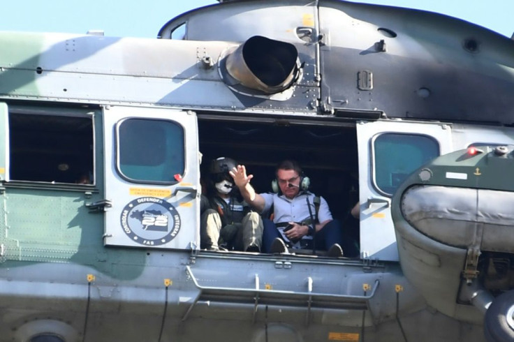 Brazilian President Jair Bolsonaro waves from a helicopter as he flies over the Brasilia rally on May 15, 2021
