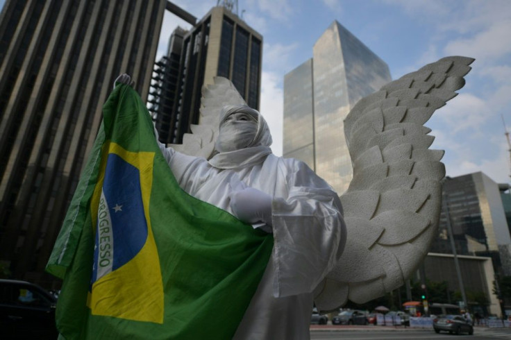 A person disguised as an angel holds a Brazilian flag during a demo in support of Brazilian President Jair Bolsonaro in Sao Paulo on May 15, 2021