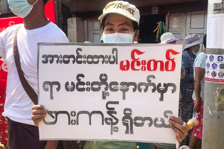 A protester in Hkapant holds a sign that reads "Stay strong, Mindat"