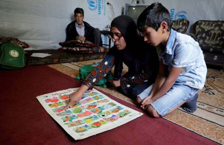 Mohammad's mother helps him revise his Arabic lesson after months without school