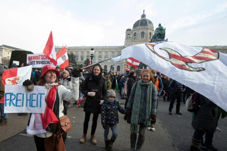 A demonstrator in Austrian capital Vienna waves a QAnon flag and carries a placard reading 'freedom'