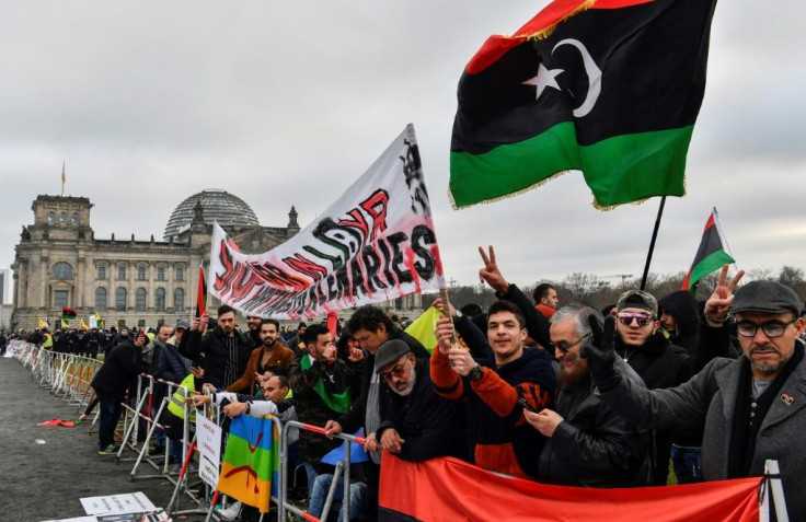 Protesters hold a banner reading "Stop war in Libya, Haftar and mercenaries" during a protest in front of the Reichstag building during the Peace summit on Libya at the Chancellery in Berlin on January 19, 2020
