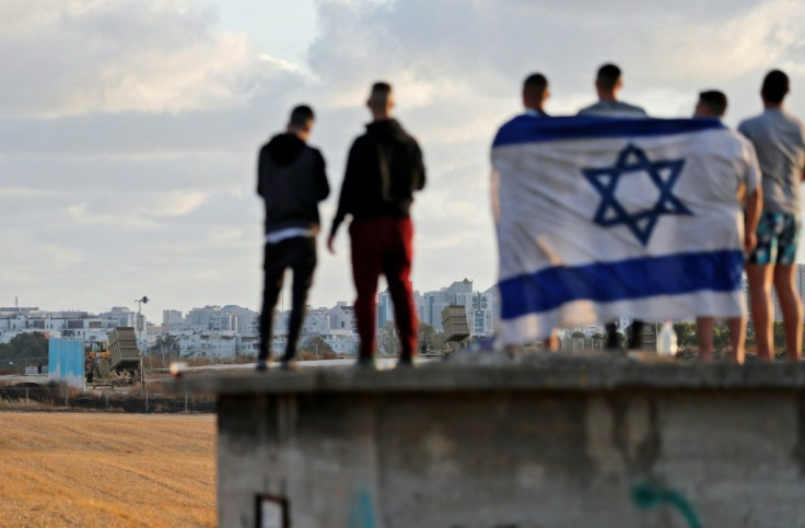 Israelis gather to watch the Iron Dome aerial defence system launch a missile to intercept a rocket launched from the Gaza Strip, above the southern Israeli city of Ashdod, on May 17