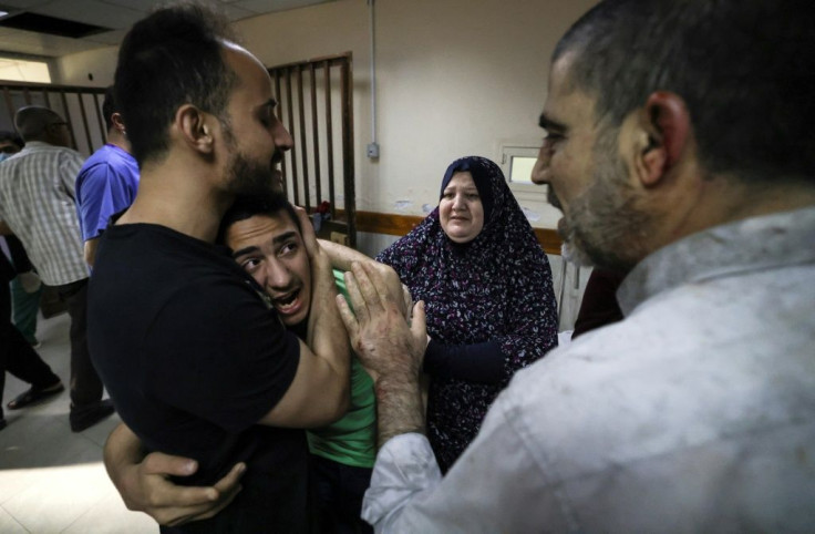 A member of the Abu Dayer family, surrounded by relatives, cries at the Al-Shifa hospital after the death of his father and cousin in an Israeli air strike on the family's home in Gaza City on May 17