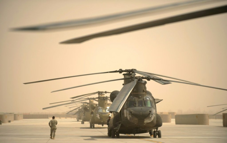A US airman walks past a row of Chinook helicopters at Kandahar airbase in southern Afghanistan, which has now been turned over to the Afghan military as US forces withdraw from the country