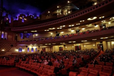 People take their seats before a projection of "Demon Slayer - Kimetsu no Yaiba" animated film at the Grand Rex cinema theatre in Paris on May 19, 2021, as cinemas reopen today with social distancing rules, as part of an easing of the nationwide lockdown 