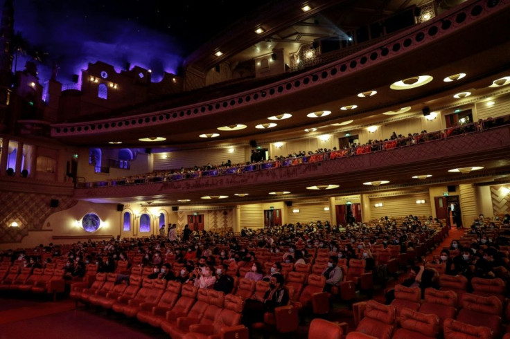 People take their seats before a projection of "Demon Slayer - Kimetsu no Yaiba" animated film at the Grand Rex cinema theatre in Paris on May 19, 2021, as cinemas reopen today with social distancing rules, as part of an easing of the nationwide lockdown 