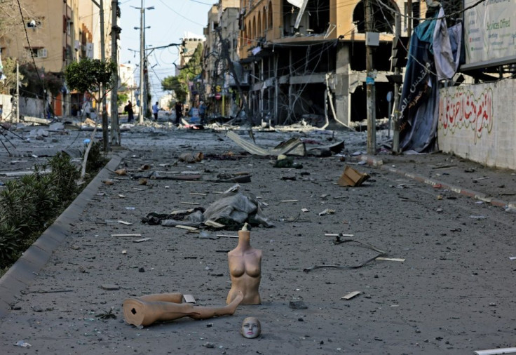 Display mannequins from a damaged clothing shop are scattered amid the debris outside the heavily-damaged Al-Jawhara Tower in Gaza City's Al-Rimal neighbourhood which was hit by Israeli airstrikes early on May 12