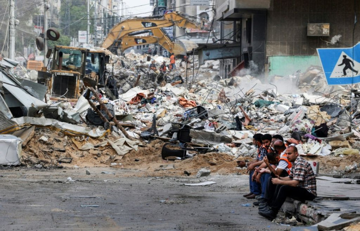 An excavator clears the rubble of a destroyed building in Gaza City's Rimal residential district on May 16
