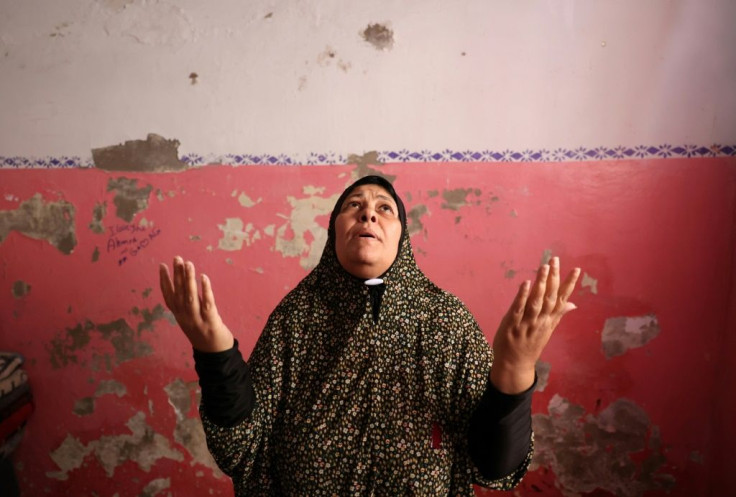 A Palestinian woman prays after her family house got damaged by an Israeli air strike in Jabaliya, in the northern Gaza Strip, on May 20, 2021