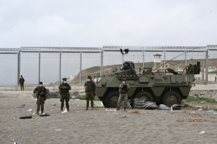 Spanish soldiers stand guard at the border fence between Morocco and Spain