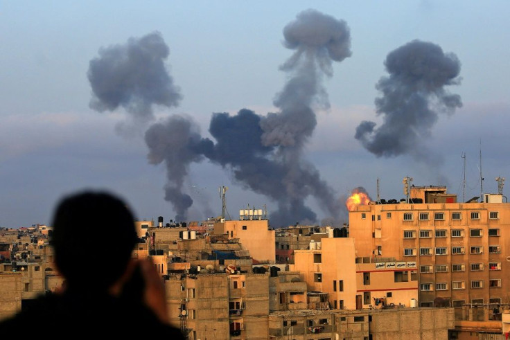 A Palestinian boy watches smoke billowing from targets during Israeli air strikes on the southern Gaza region of Khan Yunis on May 11, 2021
