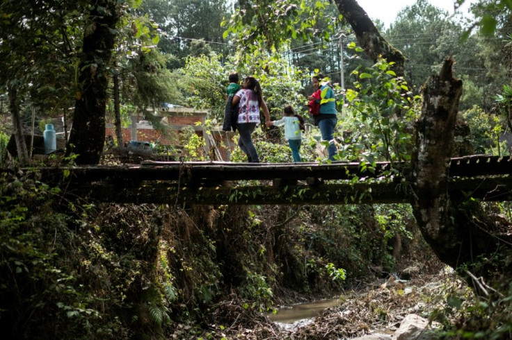 A Mexican woman who was sold into marriage crosses a bridge with her family in Metlatonoc