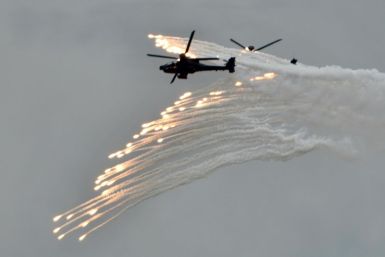 Two US-made Apache attack helicopters release flares during annual military drills in Taichung, Taiwan, in July 2020