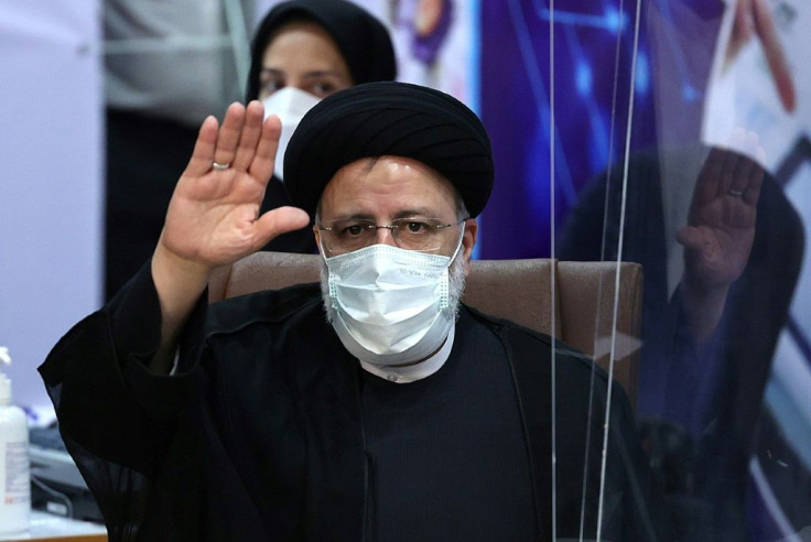 Iranian judiciary chief Ebrahim Raisi greets journalists as he arrives to submit his candidacy for Iran's June 18 presidential election