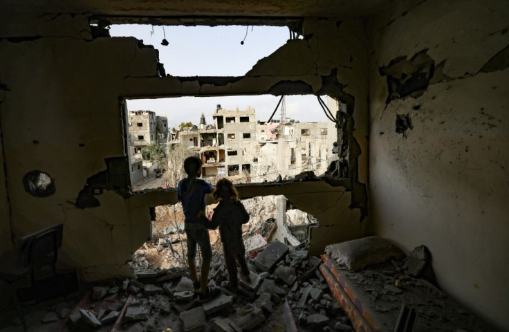 Palestinian children look out from a home damaged by Israeli bombardment in Gaza City