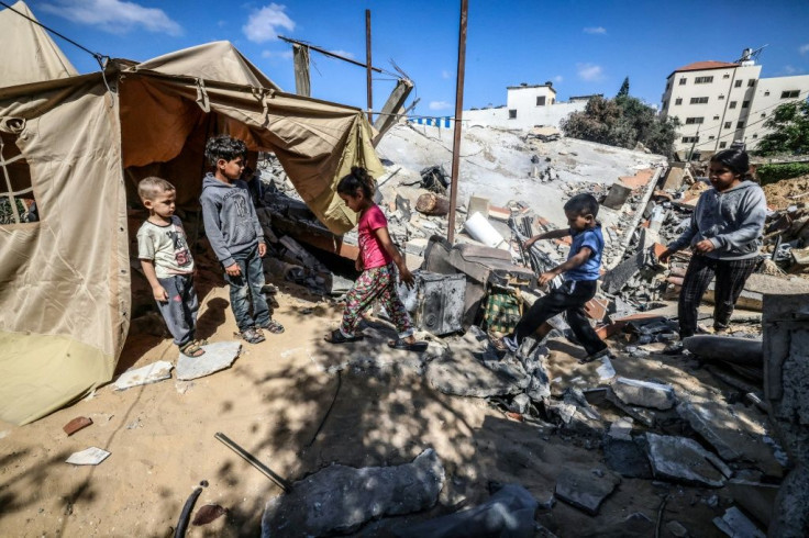 Children gather around a tent that Nazmy al-Dahdouh, a 70-year-old Palestinian man, has set up on top of the ruins of his home, destroyed in recent Israeli air strikes in Gaza City