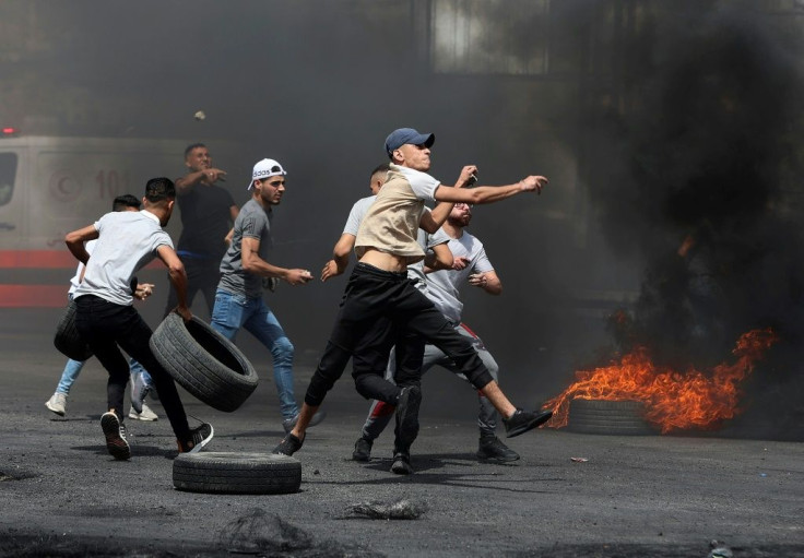 Palestinian protesters hurl rocks amid confrontations with Israeli security forces at the Hawara checkpoint south of Nablus city in the occupied West Bank on May 21