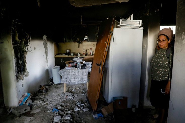 An Israeli woman stands in her home, whicht was damaged by fire during the recent intra-communal violence between Arab and Jewish Israelis, in the city of Lod near Tel Aviv on May 23