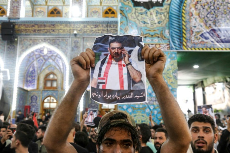 A mourner brandished a picture of murdered Iraqi anti-government activist Ihab al-Wazni during his funeral at the Imam Hussein Shrine in the central Shiite shrine city of Karbala in early May