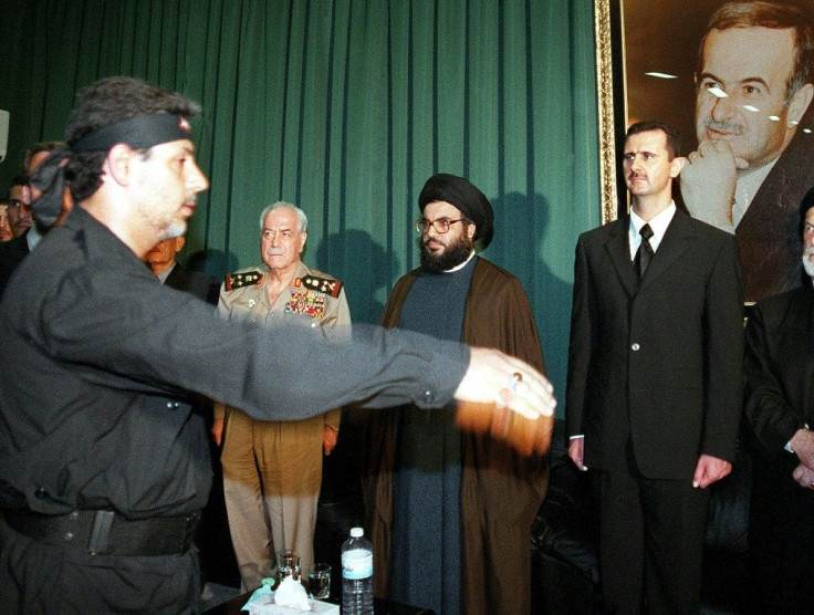 In this file photo taken on June 16, 2000, days after the death of Hafez al-Assad, the leader of Lebanese Shiite group Hezbollah, Hassan Nasrallah (C), is seen flanked by Bashar al-Assad (R) and Syrian Defence Minister Mustafa Tlass in Qardaha, Syria