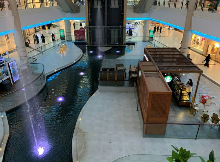 People spend time at a mall near a closed food court in the Saudi capital Riyadh, on February 5, 2021