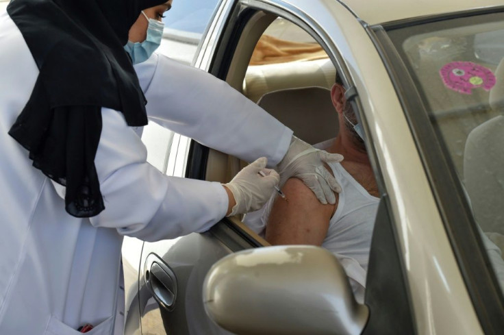 A medical worker administers a dose of the AstraZeneca Covid-19 vaccine at a drive-through vaccination center in the Saudi capital Riyadh, on March 4, 2021