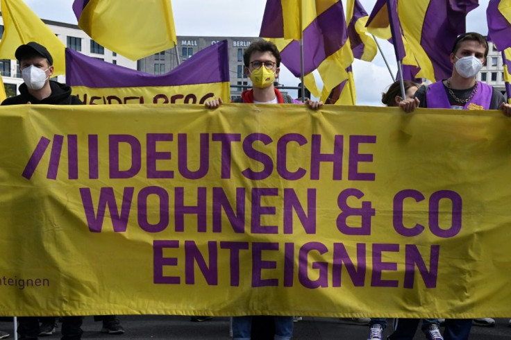 Protesters carry a banner reading 'Expropriate Deutsche Wohnen" during a demonstration against expensive rents in Berlin, on May 23, 2021.
