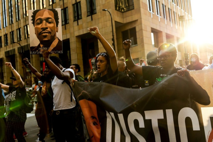 People raise their fists as they march during an event in remembrance of George Floyd in Minneapolis, Minnesota