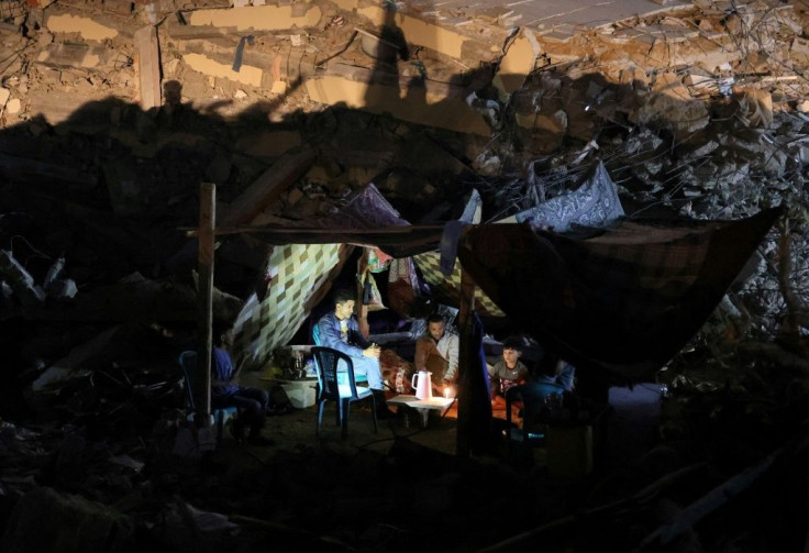 Palestinians camp out in the ruins of a building in Gaza destroyed in an air strike during Israel's 11-day bombardment of the densely populated territory