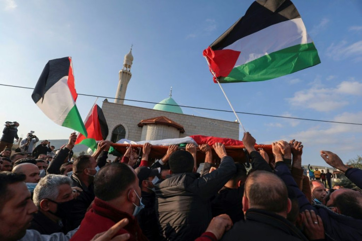 Mourners carry the body of Palestinian Atef Yussef Hanaysheh, who was shot dead by Israeli soldiers when clashes erupted during a demonstration, in the village of Beit Dajan in the Israeli-occupied West Bank on March 19