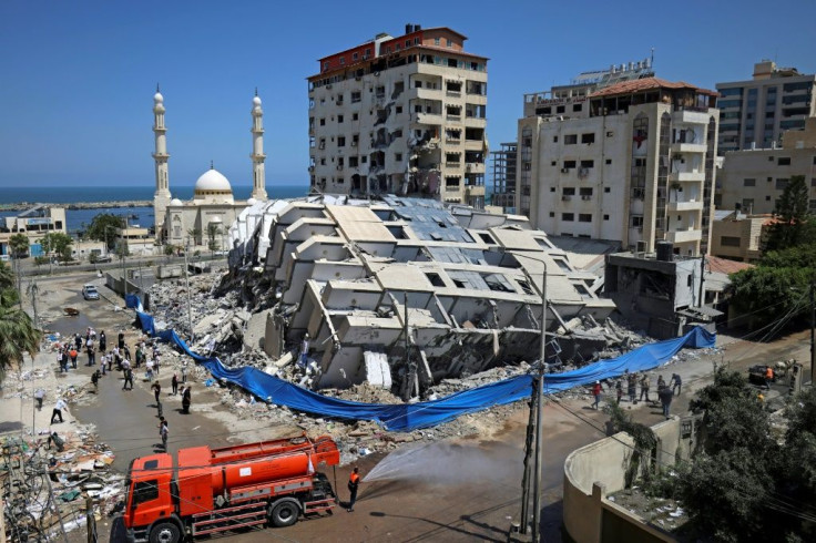 Palestinian volunteers and municipal workers clear the rubble of buildings, recently destroyed by Israeli strikes, in Gaza City's Rimal district