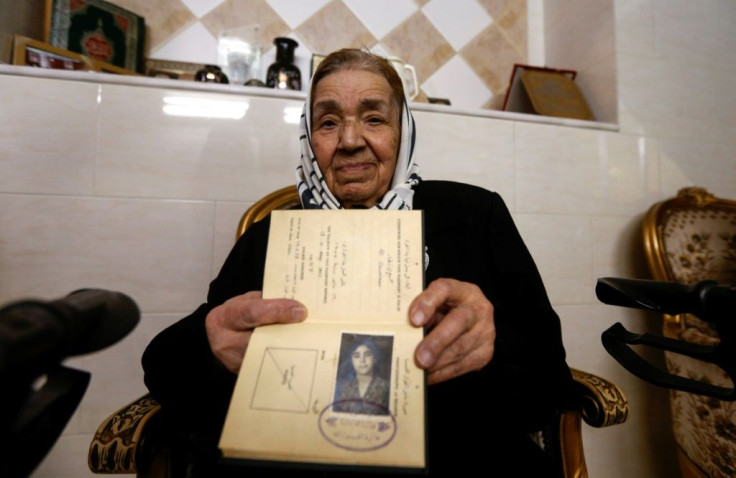 Palestinian refugee Rahma Abdul Qader, who left her home in Jaffa in 1948 aged nine and now lives in Syria, holds her original travel document