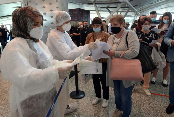 Tunisian health workers check the Covid-19 documentation of  tourists arriving at Enfidha-Hammamet International Airport near the Mediterranean resort town of Sousse