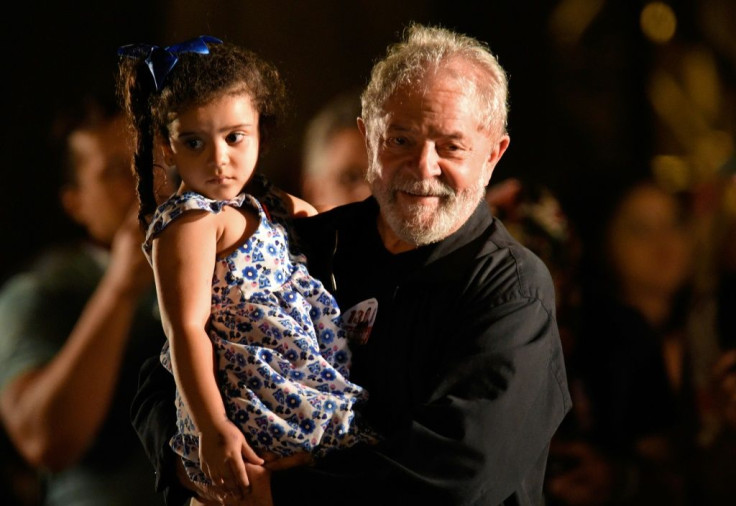 Lula, pictured holding a girl on the campaign trail in 2017, is back in 'governing mode,' say analysts